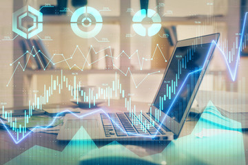 Financial chart drawing and table with computer on background. Double exposure. Concept of...