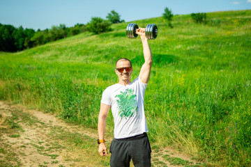 Man pushing dumbbell in hand over head