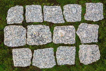 Granite paving stones on a green field