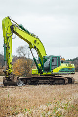 Modern excavator performs excavation work on the farm field.