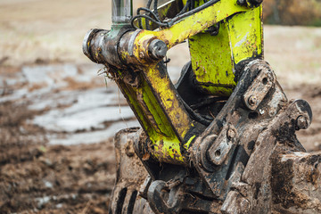 Modern excavator performs excavation work on the farm field.