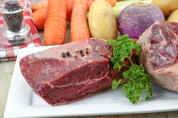 vegetables and raw meat for pot on fire on a wooden table
