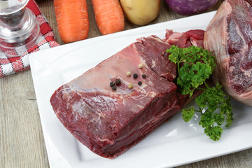 vegetables and raw meat for pot on fire on a wooden table