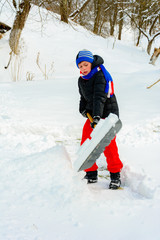Fototapeta na wymiar The boy shovels the snow near his house in winter.