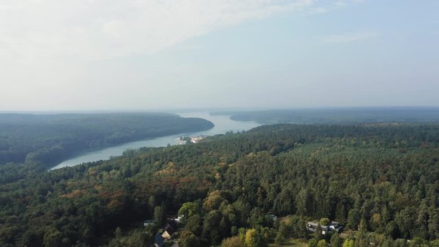 High Aerial dolly in above forest towards Lake Werbellinsee, Germany