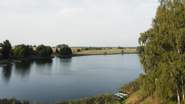 Aerial circling shot above lake Krummer with old wooden boats, Germany