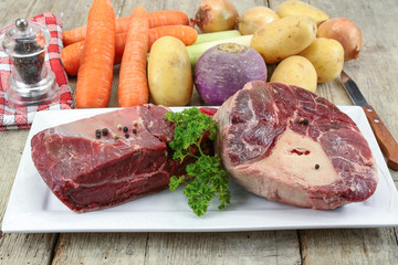 vegetables and raw meat for pot on fire on a wooden table
