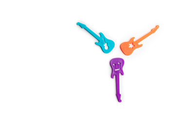 Miniature Guitars on White Background. Colorful musical instruments made of plastic.
