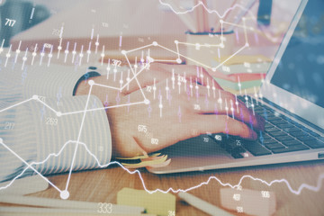 Multi exposure of stock market graph with man working on laptop on background. Concept of financial analysis.