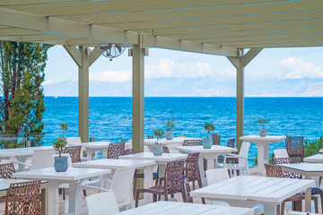 Beautiful tropical restaurant and beach with turquoise water. Corfu island, Greece. - obrazy, fototapety, plakaty