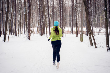 Image on back of young athlete girl running in winter park