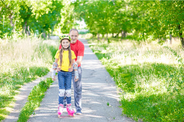 Portrait of the father and his daughter wearing a protective helmet for roller skating. Empty space for text