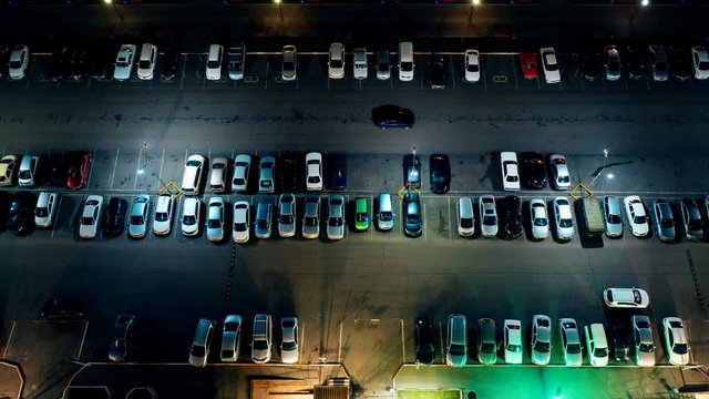 the movement of cars in the Parking lot at night, timelapse