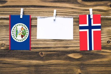Hanging flags of Belize and Bouvet Islands attached to rope with clothes pins with copy space on...