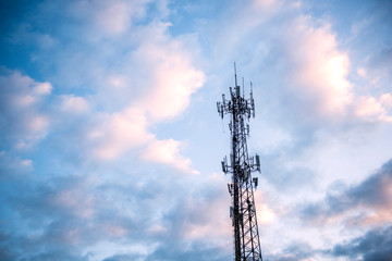 Wireless communication tower with blue sky and white clouds as background