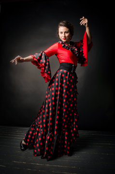 Carmen beautiful woman in red dress on dark background