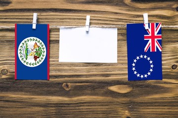 Hanging flags of Belize and Cook Islands attached to rope with clothes pins with copy space on...