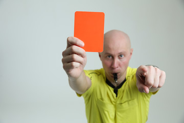 red card of a football referee close-up. hard gesture of a football referee. the referee shows a...