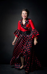 Fototapeta na wymiar Carmen beautiful woman in red dress on dark background