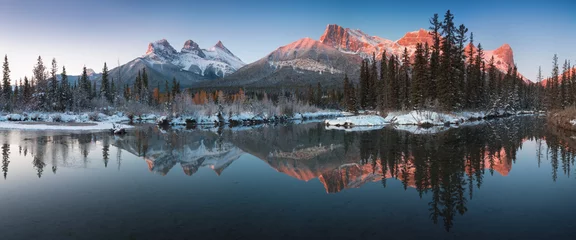 Foto auf Acrylglas Kanada Fast fast perfektes Spiegelbild der Three Sisters Peaks im Bow River. In der Nähe von Canmore, Alberta, Kanada. Die Wintersaison kommt. Bärenland. Schönes Landschaftshintergrundkonzept.