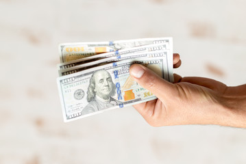 Man's hands holding hundred dollar bills. Business concept