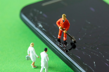 A miniature Garbage man is cleaning the surface of a shattered smartphone screen and a medical team...