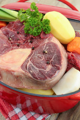vegetables and raw meat for pot on fire on a wooden table