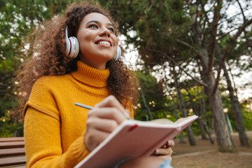 Curly woman listening music with headphones
