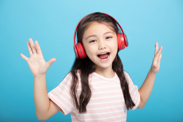 happy little girl with headphones listening and singing song