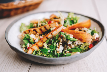 Healthy vegetarian dinner or lunch.  Salad with caramelized grilled pear, walnuts, blue cheese and pomegranate seeds.