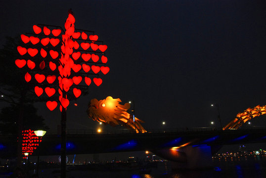 Love Bridge with view of Dragon Bridge illuminated at night, Da Nang city center, Vietnam 