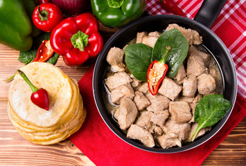 Mexican cuisine. Fajita and tortilla on red textile. Cooking. Ingredients. Recipe