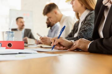 Obraz premium Group of young business professionals having a meeting. Diverse group of coworkers discuss new decisions, future plans and strategy. Creative meeting and workplace, business, finance, teamwork.