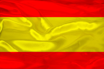 beautiful photo of the colored national flag of the modern state of Spain on a textured fabric, concept of tourism, emigration, economics and politics, closeup