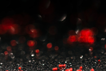 black and red abstract background with defocused glitter effect,  shiny and festive bokeh image with copy space