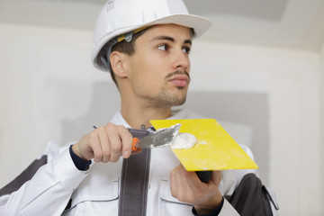 man plastering wall with trowel