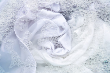 Obraz na płótnie Canvas Soak white clothes in powder detergent water dissolution. Laundry concept