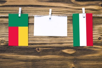 Hanging flags of Benin and Hungary attached to rope with clothes pins with copy space on white note...
