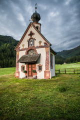 Dolomites, Italy - July, 2019: Green alpine valley with view of Santa Maddalena village church, Val di Funes, Dolomiti Mountains, Italy