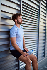 Sportsman making pause during exercising in urban area.