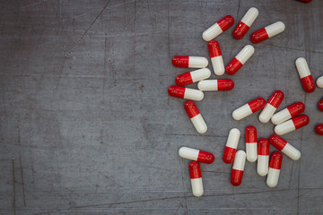 Red drugs pills capsules on dark moody background overdose concept