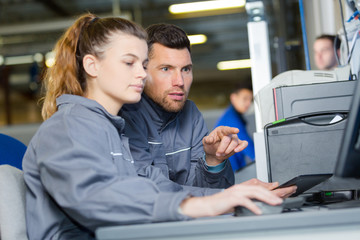 teacher helping students with laptop