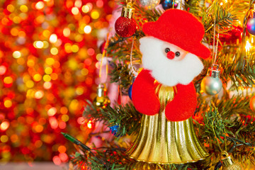 Red Santa doll is an ornament on a Christmas tree against light background for Christmas Day and New Year holidays background.