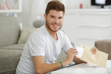 Fototapeta premium happy young man holding a letter indoors