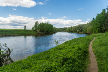Obraz premium summer riverscape with blue sky, clouds and water reflections