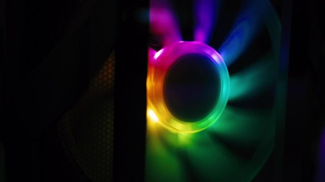 Slow motion shot of colourful fans spinning inside a gaming computer