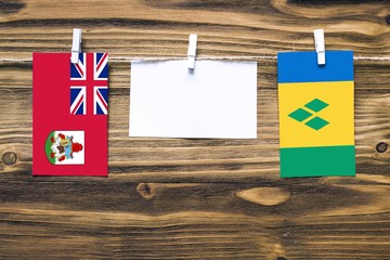 Hanging flags of Bermuda and Saint Vincent And The Grenadines attached to rope with clothes pins...