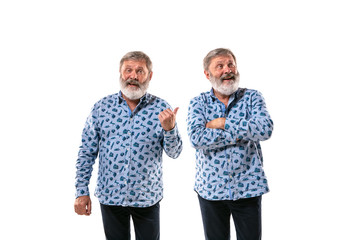 Senior man arguing with himself on white studio background. Concept of human emotions, expression,...