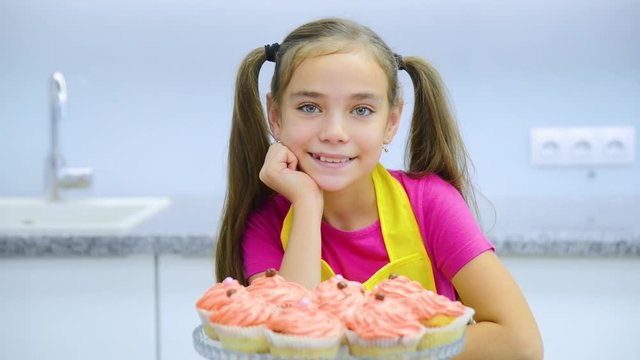 Smiling girl takes out the capcake from the gift box