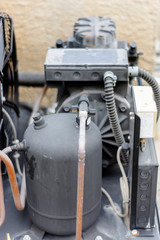 closeup of an old rusty and dusty compressor of heavy duty air conditioning system kept on the roof in bright and clear sunny day